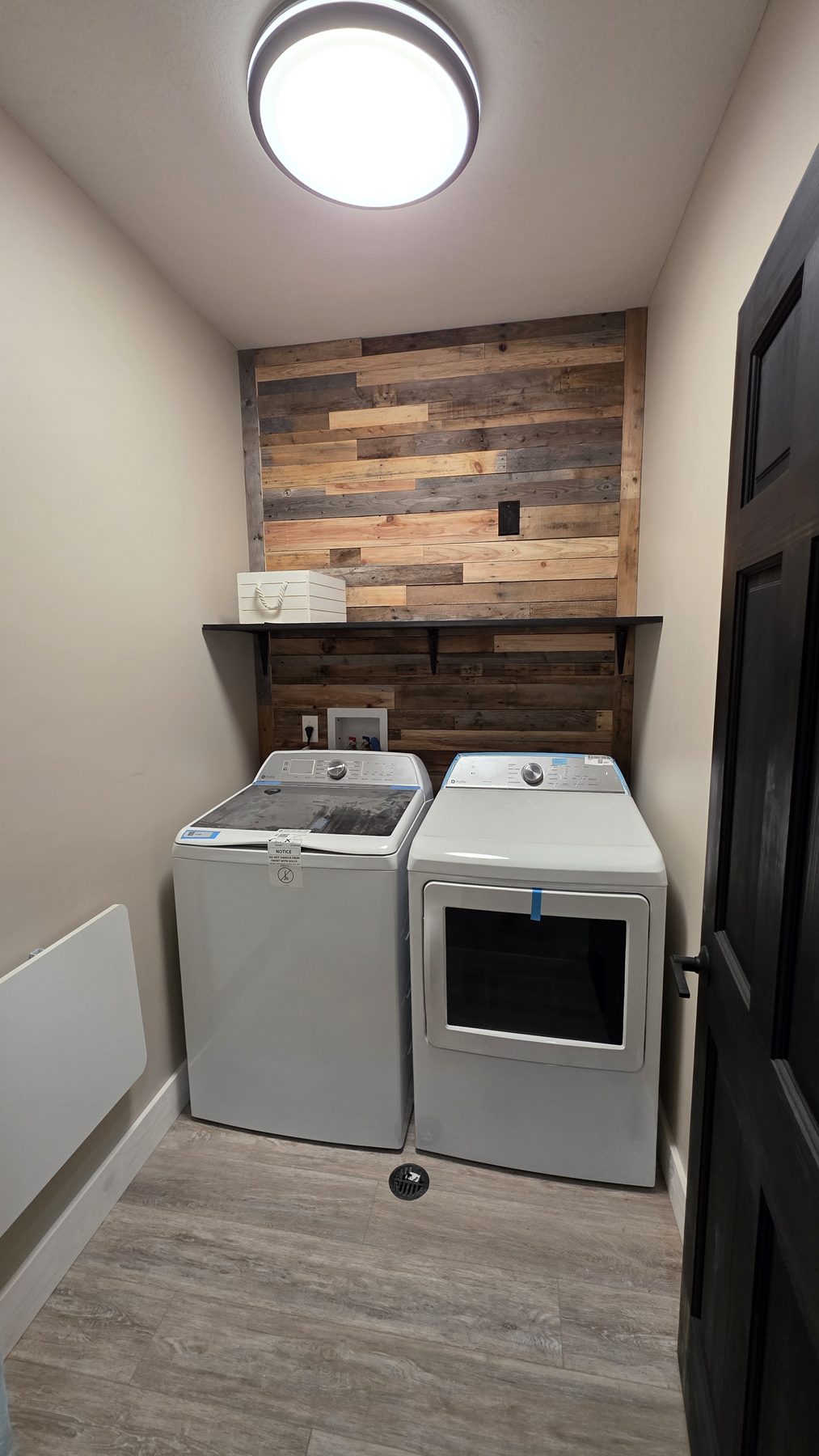 Laundry room with full-size washer and dryer and rustic accent wall