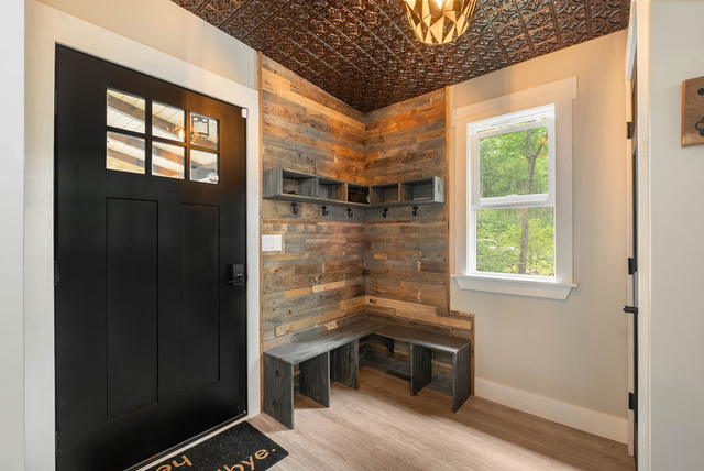 The main-floor foyer: pressed-copper tin ceiling, reclaimed pallet wall, hooks a