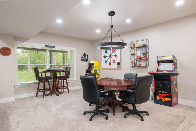 The lower-level game room — Ms. Pac-Man and X-Men arcade cabinets, a card table,