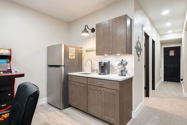The lower-level kitchenette and wet bar: full-size fridge, sink, and coffee so n
