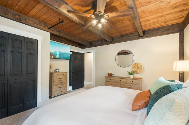 The same room from the door — dresser, round mirror, and the window onto the dec
